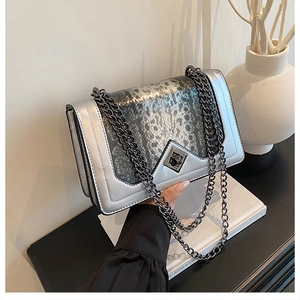Close-up of silver crossbody bag featuring snakeskin flap and black diamond twist lock