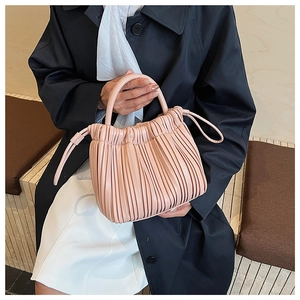 Detail view of pink pleated handbag with soft leather texture and elegant drawstring