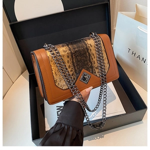 Close-up of brown crossbody bag with snake skin pattern in premium gift box