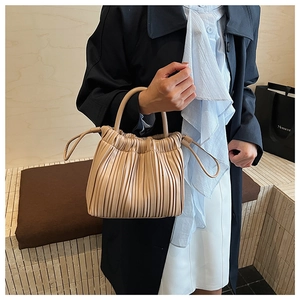 Macro detail of beige pleated cloud bag with soft texture and elegant drawstring design