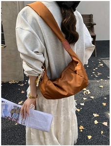 Vista posteriore di una borsa a mezzaluna in nylon caramello con tracolla larga e perline