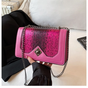 Detail of rose pink crossbody bag showing snake pattern flap and metallic twist lock