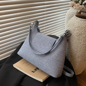 Light blue textured crossbody dumpling bag with silver hardware and a top handle