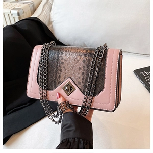 Detail of pink and snakeskin patchwork shoulder bag with metal chain strap