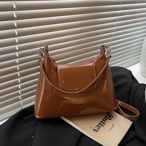 Brown patent leather tote bag with metal hooks and adjustable strap for shoulder wear