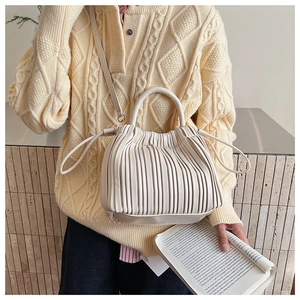 Detail of off-white pleated handbag with drawstring closure and fine leather texture