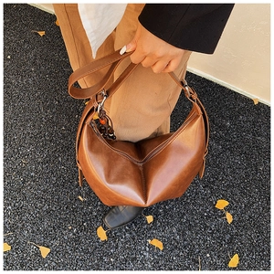 Vue détaillée du sac en cuir marron vintage avec pliage géométrique et breloque perlée