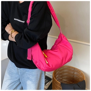 Dettaglio borsa a mezzaluna in nylon magenta con perline di legno e tracolla