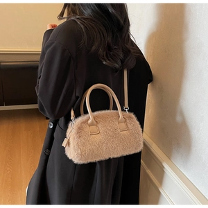 Detailed shot of beige fluffy faux fur handbag with leather handles and crossbody strap