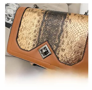 Detail of vintage caramel crossbody bag featuring snakeskin pattern and silver rotary lock