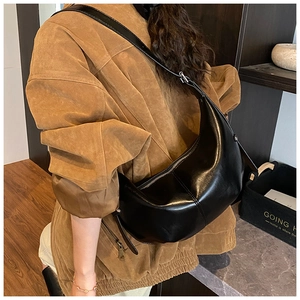 Détail du sac bandoulière croissant en cuir noir avec fermeture éclair et sangle réglable