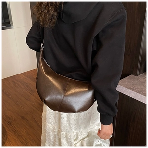 Vue détaillée du sac hobo demi-lune marron foncé avec coutures et texture de cuir
