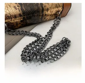 Close-up of premium gunmetal chain strap and snakeskin pattern on vintage crossbody bag