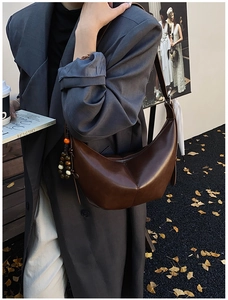 Détail d'un sac demi-lune marron foncé avec perles ethniques et cuir poli de haute qualité