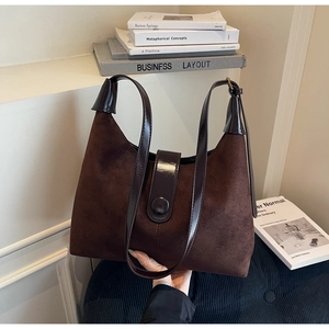Detail of dark coffee shoulder bag showing contrast between suede and glossy leather textures