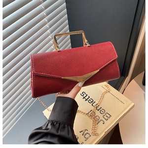 Detail showing red grain texture crossbody bag with gold handle and V-shaped magnetic closure