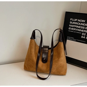 Detailed texture of brown vintage suede tote bag with contrast glossy leather handles