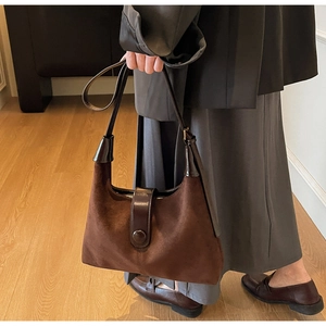 Close-up of vintage dark brown suede tote with smooth leather handles and round buckle