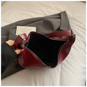 Détail du sac hobo croissant en cuir bordeaux avec des finitions métalliques argentées