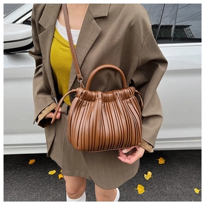 Detail of brown pleated handbag featuring soft texture and versatile crossbody strap