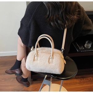 Detail of plush cream faux fur bag featuring leather handles and detachable shoulder strap