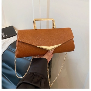 Detail of brown litchi pattern bag with gold triangle buckle and metal handle