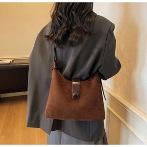 Detailed back view of a vintage dark brown suede tote bag with a decorative round buckle strap