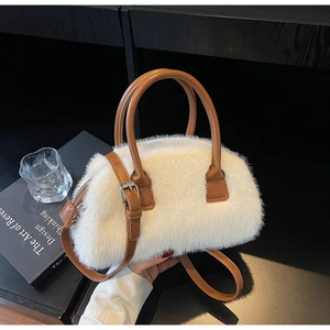 Detail of white faux fur handbag with brown leather handle and silver metal buckle