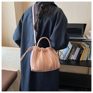 Detailed view of apricot pleated leather bag with a drawcord closure and soft texture