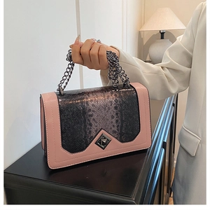 Detail of elegant shoulder bag featuring pink leather and grey python texture with chain