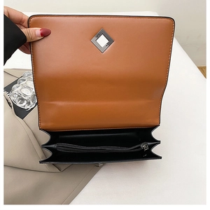 Detail view of the brown leather bag interior with zipper pocket and metal buckle