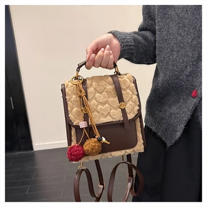 Close-up of winter backpack featuring heart-patterned plush fabric and decorative tassel