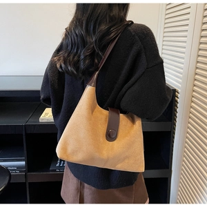 Detail of high-capacity camel suede shoulder bag with brown leather trim and retro buckle