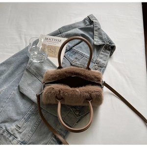 Detailed close-up of a brown faux fur Boston bag featuring a leather handle and strap