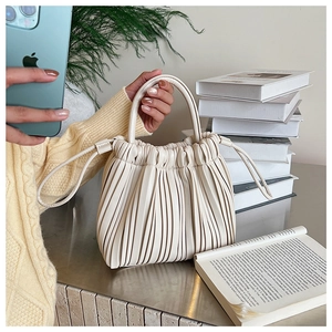 Detail of off-white pleated cloud bag showing soft leather texture and drawstring handle