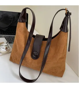 Detail of vintage brown suede tote bag with durable handles and magnetic buckle