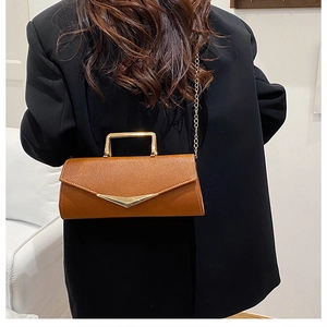 Brown litchi grain leather crossbody bag with golden V-buckle and metal handle details