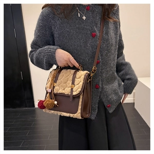 Detail of vintage brown leather backpack with beige faux fur trim and plush ball charms