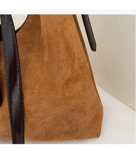 Detailed macro view of the soft brown suede fabric and smooth synthetic leather strap