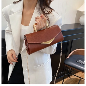 Close-up of brown litchi grain leather bag with gold V-shape clasp and metal chain