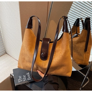 Detail of vintage mustard yellow suede shoulder bag with brown leather strap and buckle