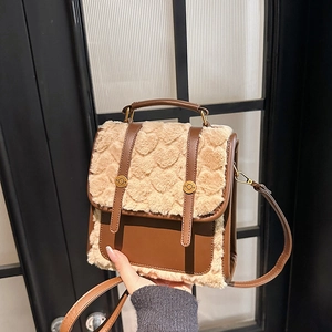 Detailed shot of retro brown leather and beige faux fur handbag with gold buckle accents