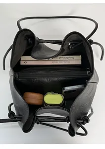 Interior view of black drawstring bucket bag showing compartments and spacious storage