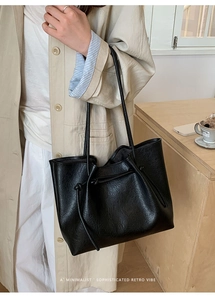 Detail shot of black matte PU leather tote bag with stylish drawstring knot accents