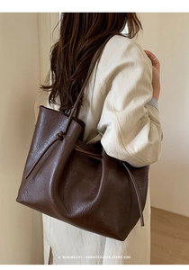 Detail view of large dark brown drawstring tote bag with soft leather texture and retro vibe