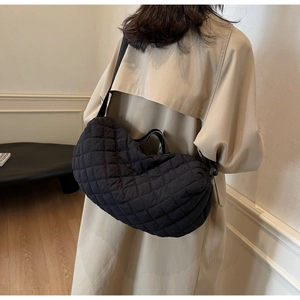 Detailed view of the black quilted nylon hobo bag featuring premium diamond stitching texture