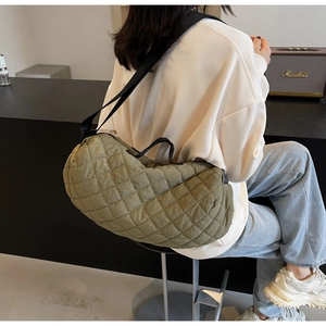 Detailed back view of a large olive green quilted bag with crescent shape and black strap