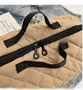 Detail of smooth double black zippers on a khaki quilted canvas dumpling shoulder bag