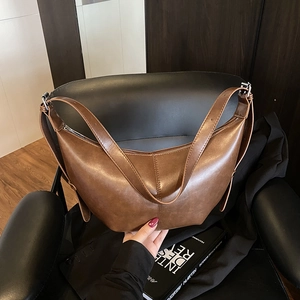 Sac hobo minimaliste en cuir marron foncé avec bandoulière réglable et forme demi-lune