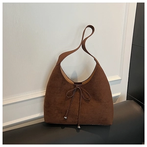 Detailed view of the dark brown suede hobo bag with delicate bow knot and metallic beads